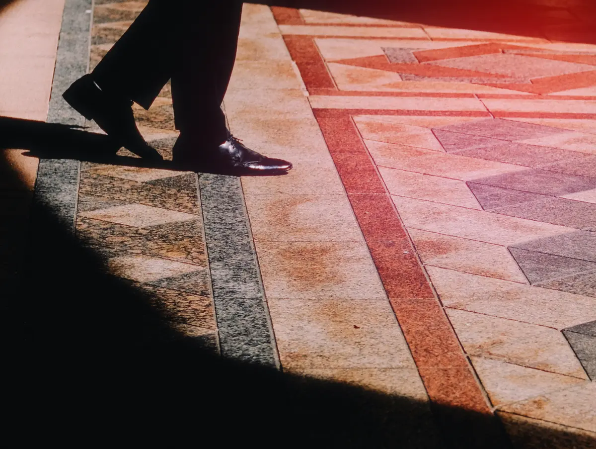 Person walking across a patterned stone floor